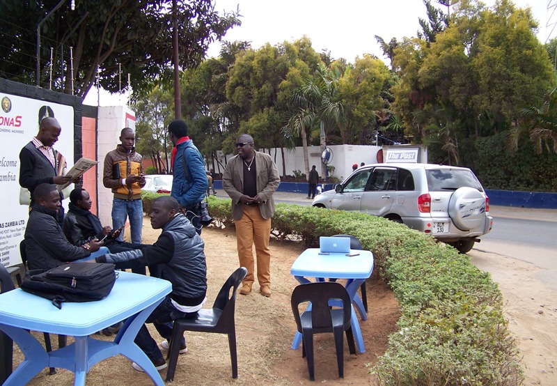 Journalists from Zambia's The Post, working from their "mobile newsroom" on the street outside the publication's shuttered offices on July 13, 2016. The newspaper has continued to publish a truncated print version since Zambia's Revenue Authority seized its assets and closed its offices in June 2016. Photo: IPI