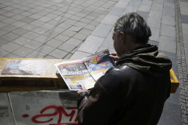 A man reads a newspaper showing election results in Belgrade, Serbia, 04 April 2022. Unofficial results of the general elections held in Serbia on 03 April 2022 show Vucic and his Serbian Progressive party (SNS) as overall winners. EPA-EFE/ANDREJ CUKIC