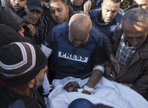 Relatives of Palestinian journalist Samer Abu Daqqa, cameraman for Al Jazeera, who was killed during Israeli air strikes in the southern Gaza Strip, with press crews next to his wrapped body, outside Nasser Hospital in Khan Yunis, southern Gaza Strip, 16 December 2023. EPA-EFE/HAITHAM IMAD