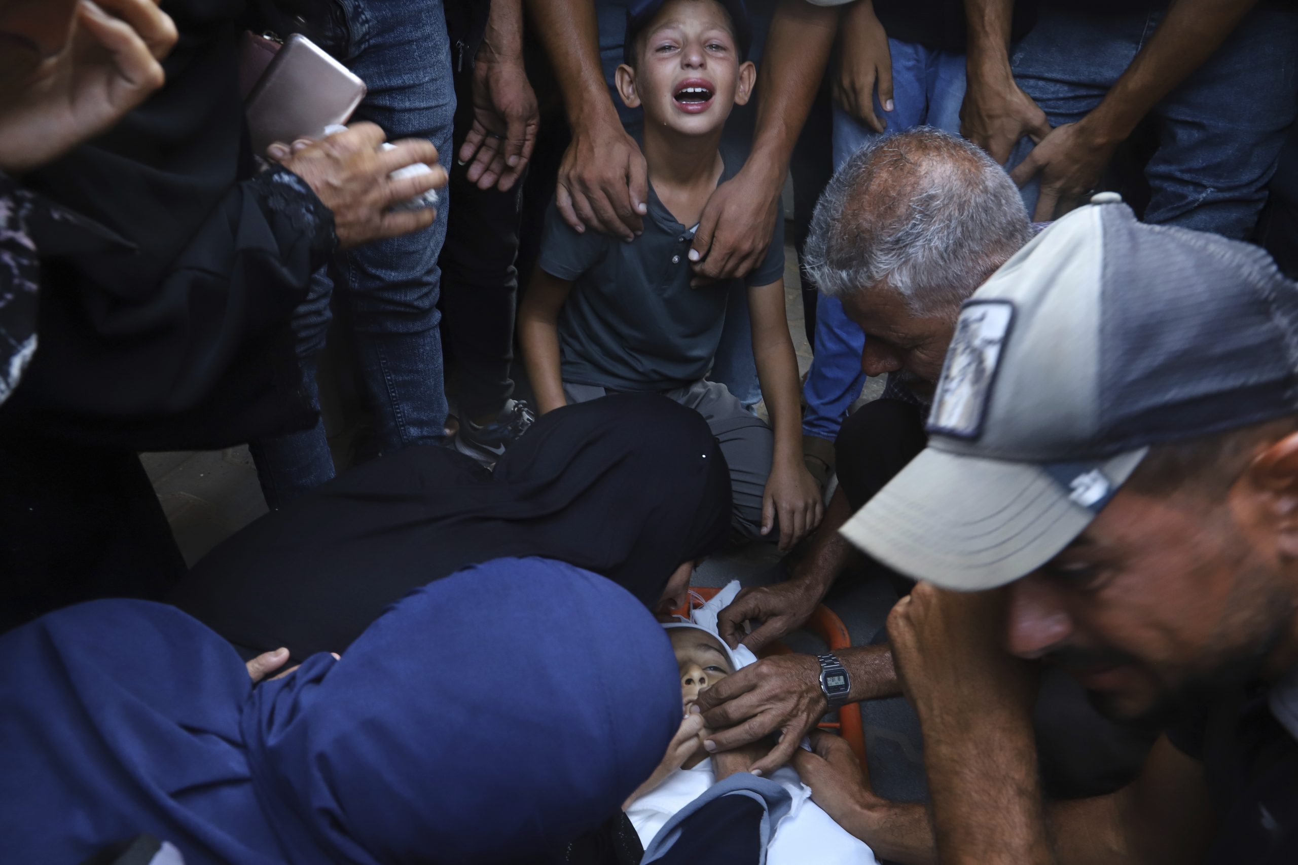 Palestinian relatives mourn over the body of 13-year-old Karim Qdeih, who was killed along with others in overnight Israeli strikes, during his funeral outside Nasser Hospital in Khan Younis, southern Gaza Strip, Saturday, Aug. 23, 2025. (AP Photo/Mariam Dagga, File)
